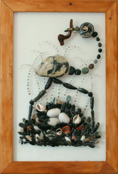 Avestruz junto a su nido con huevos, realizado con piedras naturales sobre plexiglás bajo la luz del sol.