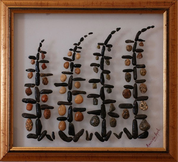 Bosque estilizado realizado con piedras naturales sobre plexiglás, representando varios árboles mediante formas simples y armoniosas.