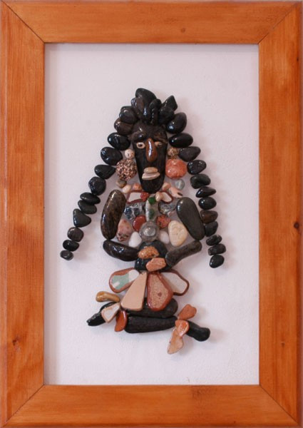 Figura de un indígena realizada con piedras naturales sobre plexiglás, representada con largos cabellos y vestimenta tradicional.