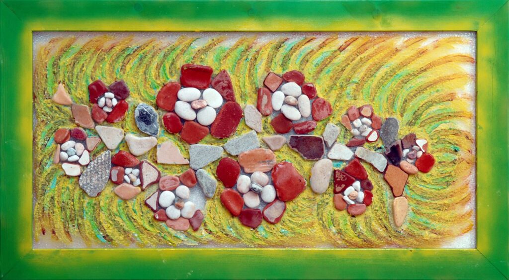 Composición floral realizada con piedras naturales y fragmentos de cerámica sobre un fondo de colores vibrantes inspirado en una enredadera en flor.