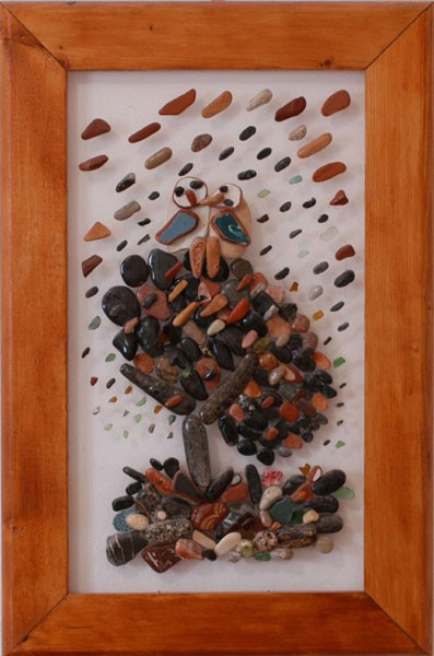 Dos pequeños pájaros juntos sobre un nido, realizados con piedras naturales sobre plexiglás.