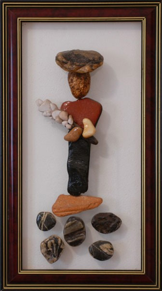 Figura humana realizada con piedras naturales sosteniendo un símbolo de paz sobre vidrio.