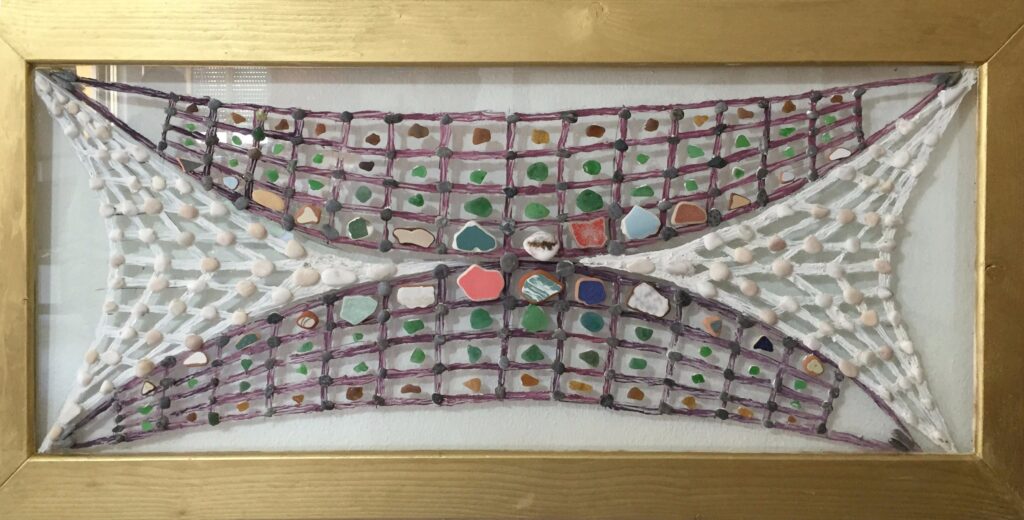 Composición abstracta realizada sobre vidrio con líneas que forman una red o tejido simétrico, enriquecida con piedras marinas, fragmentos de cerámica y vidrio de colores.